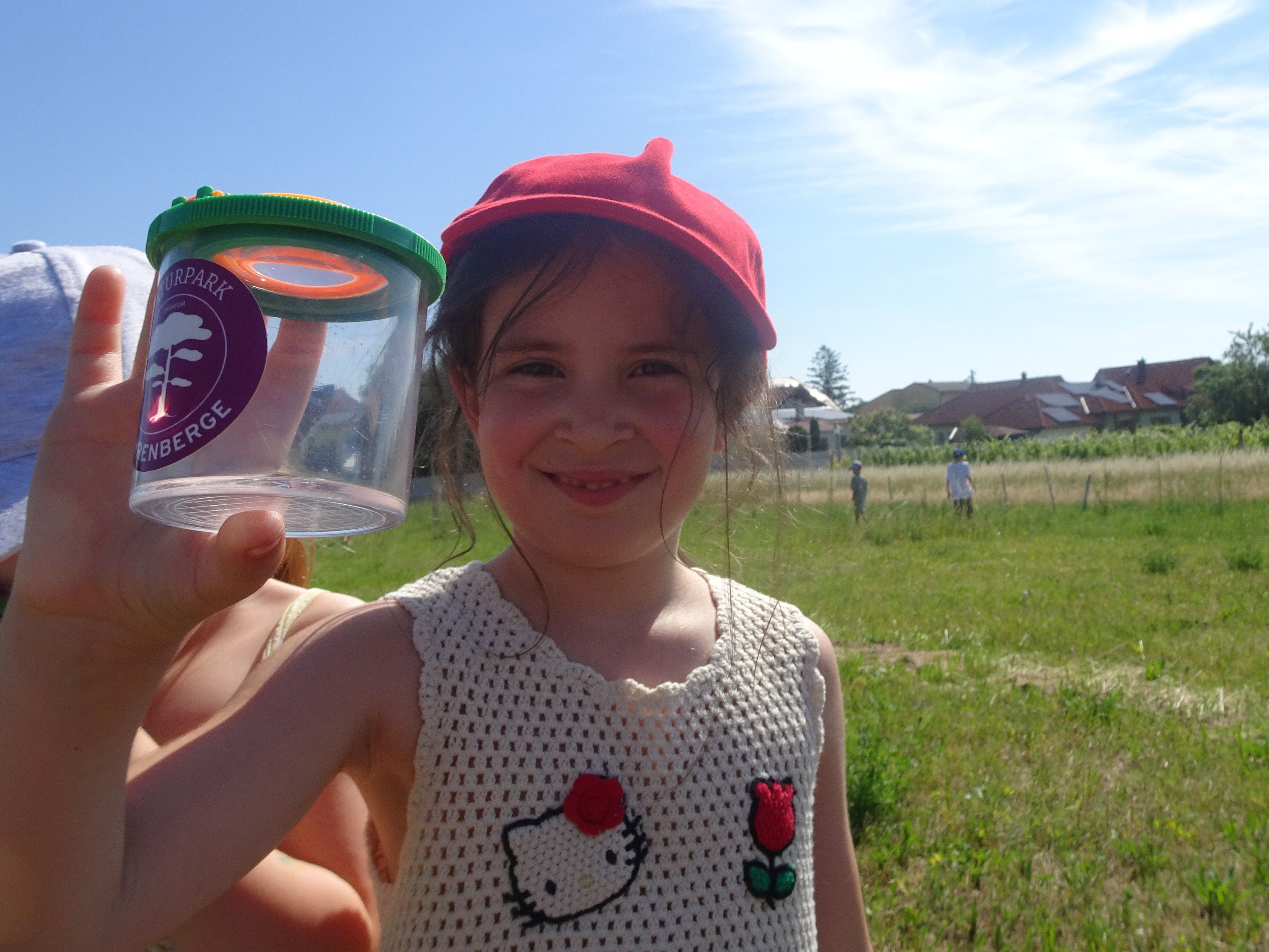 Kind mit Becherlupe