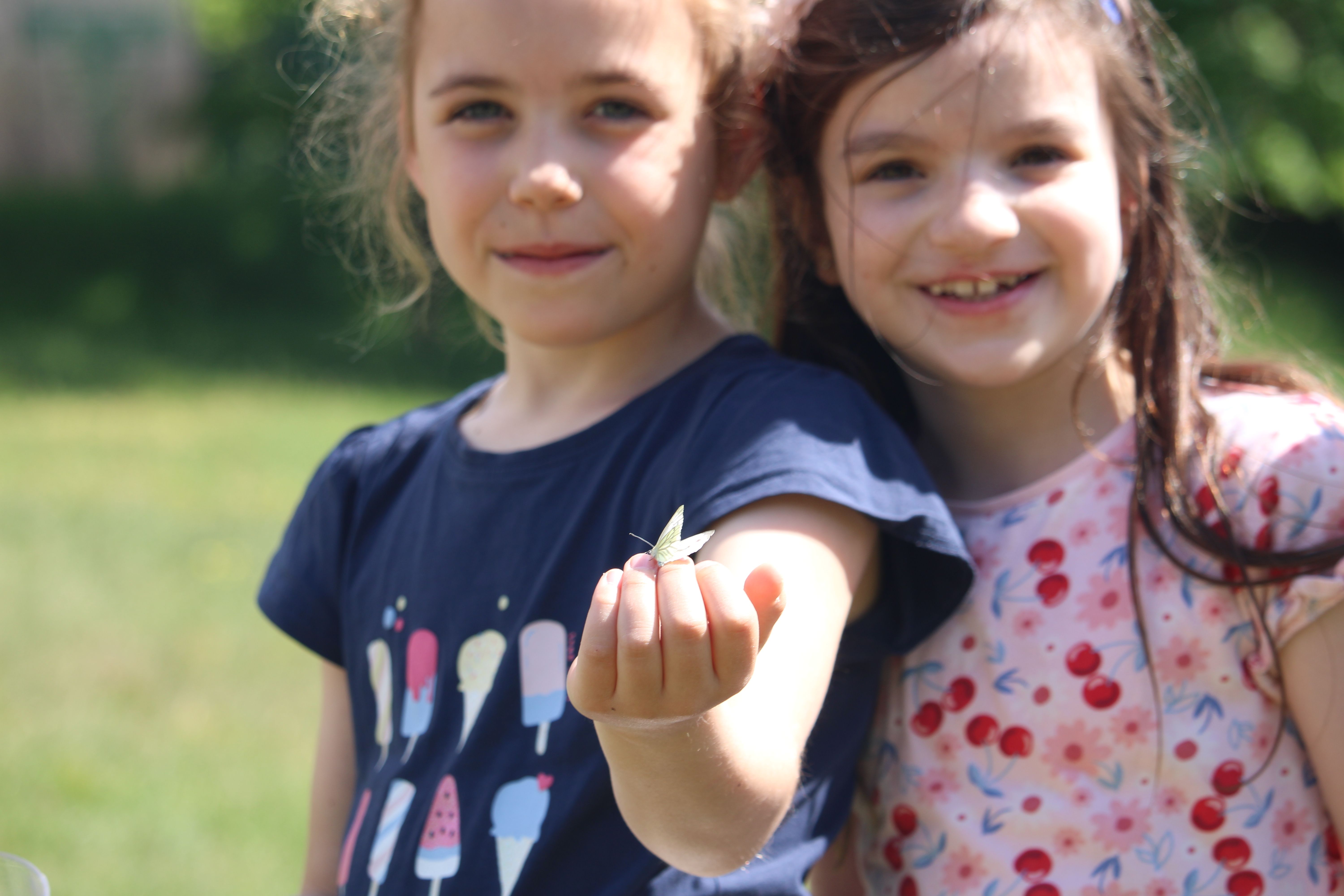 Kinder mit Schmetterling auf der Hand