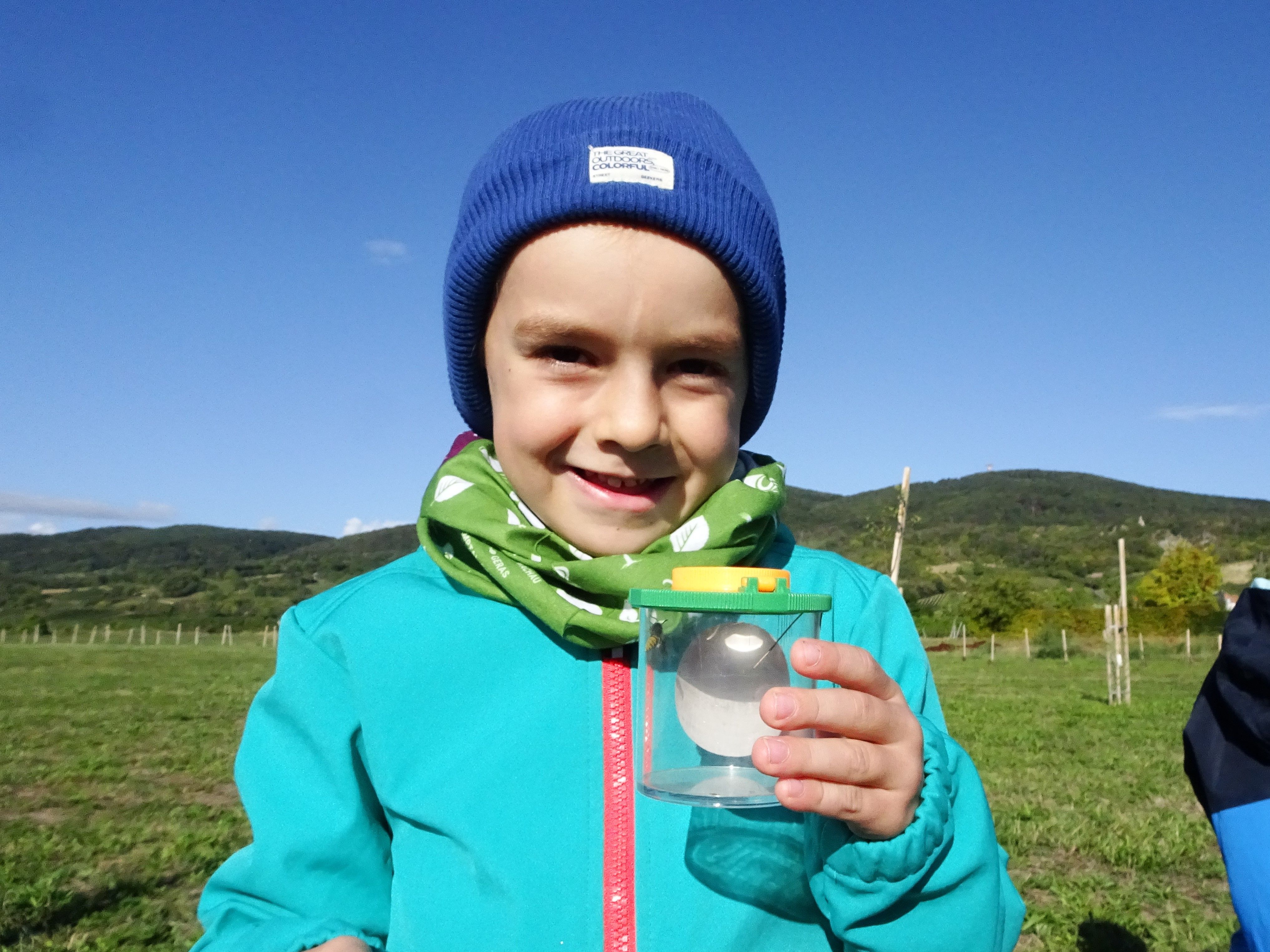 Kind mit Becherlupe