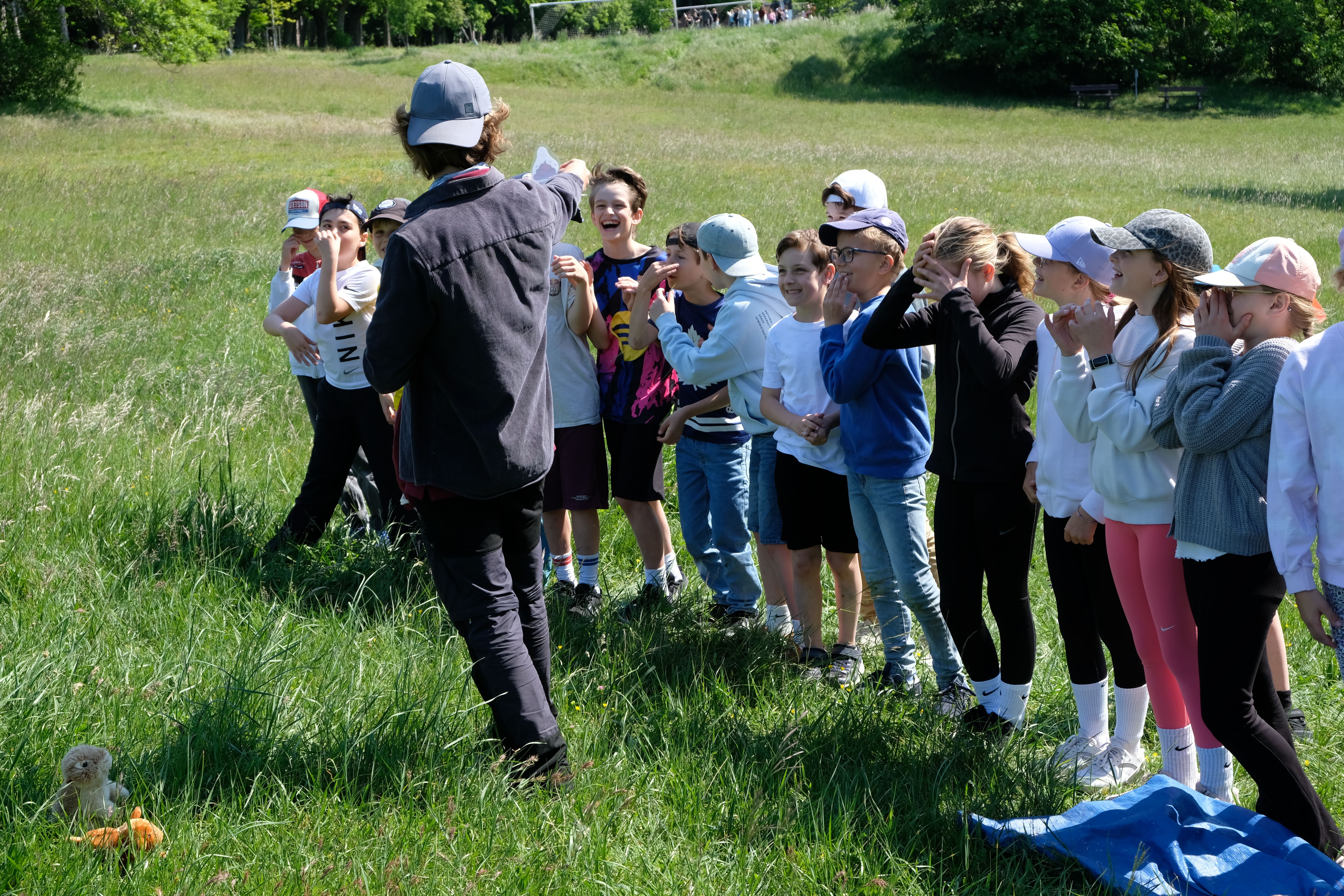 Kinder bekommen einen Gegenstand zur Pantomime gezeigt