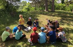 Die Schüler:innen freuen sich gemeinsam mit Naturpädagogin Melanie auf die Becherlupensuche.