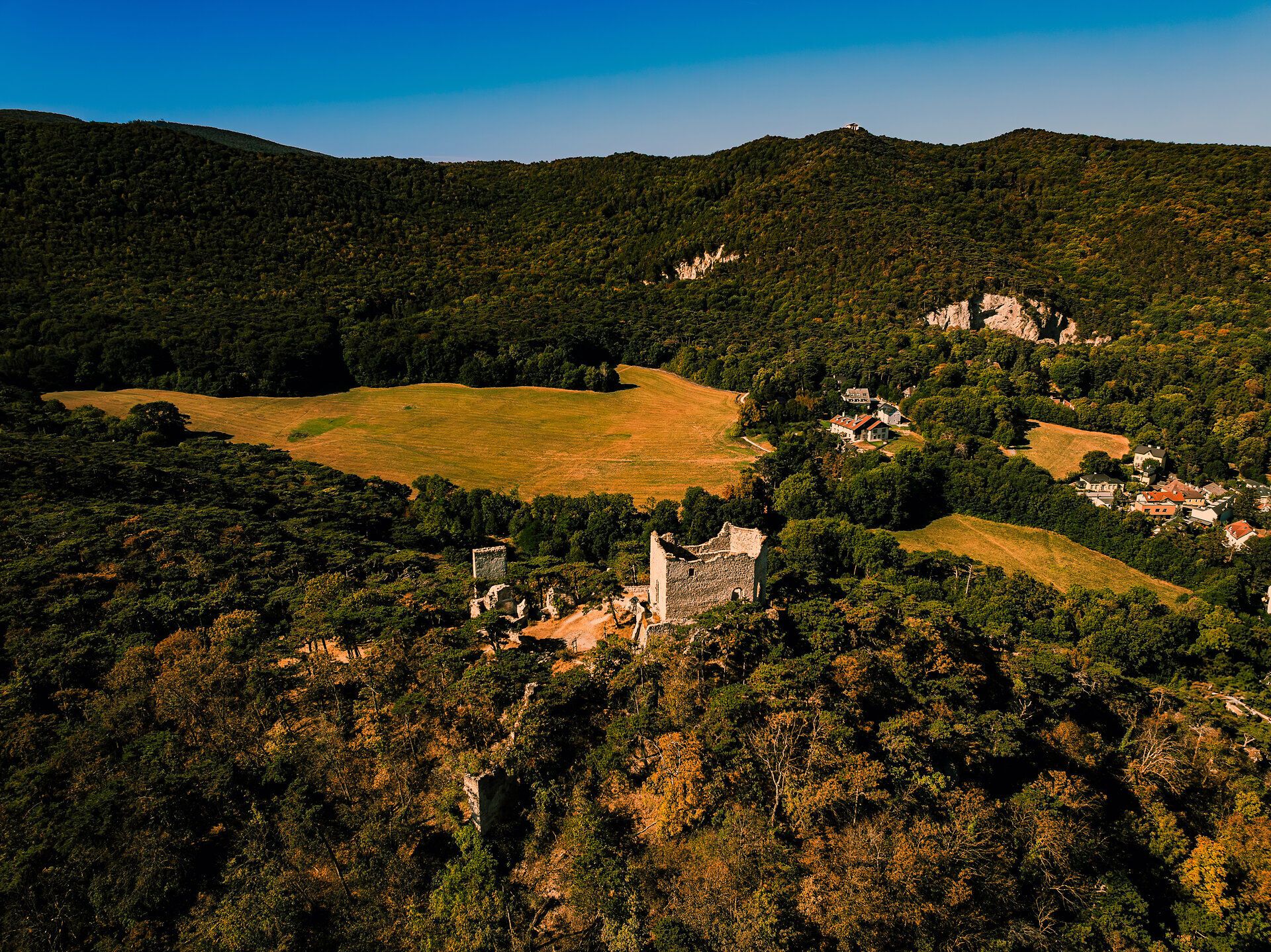 Die Burgruine Mödling thront majestätisch über der sanften Hügellandschaft des Wienerwaldes. Umgeben von üppigem Grün und blühenden Wiesen, lädt die malerische Kulisse zu einem unvergesslichen Ausblick ein. Hier spürt man die Ruhe der Natur und die Geschichte, die in den alten Mauern lebendig wird.