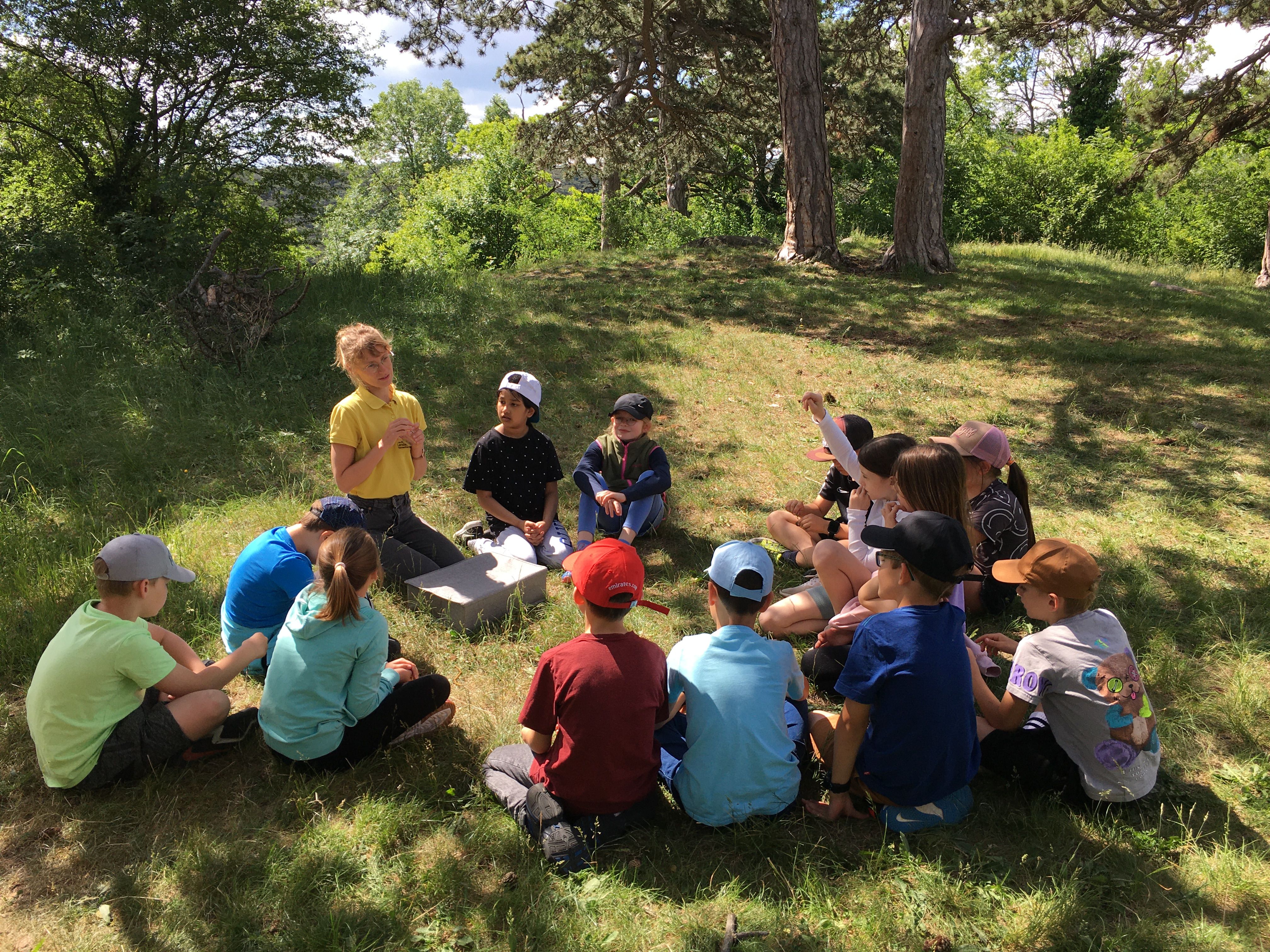 Die Schüler:innen freuen sich gemeinsam mit Naturpädagogin Melanie auf die Becherlupensuche.