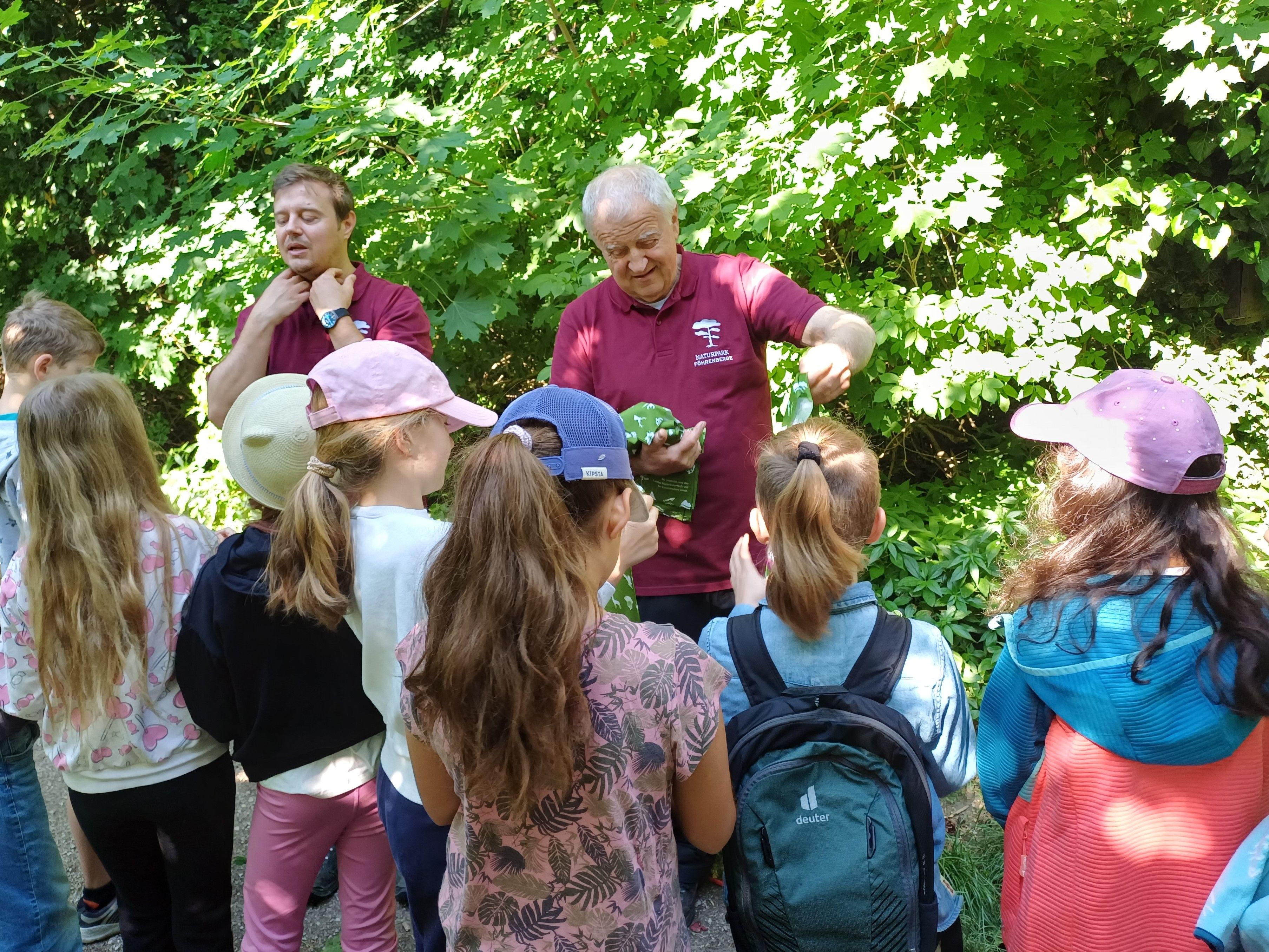 Konrad Brunnhofer (operativer Geschäftsführer Naturpark Föhrenberge) schenkt den Kindern einen Schlauchschal