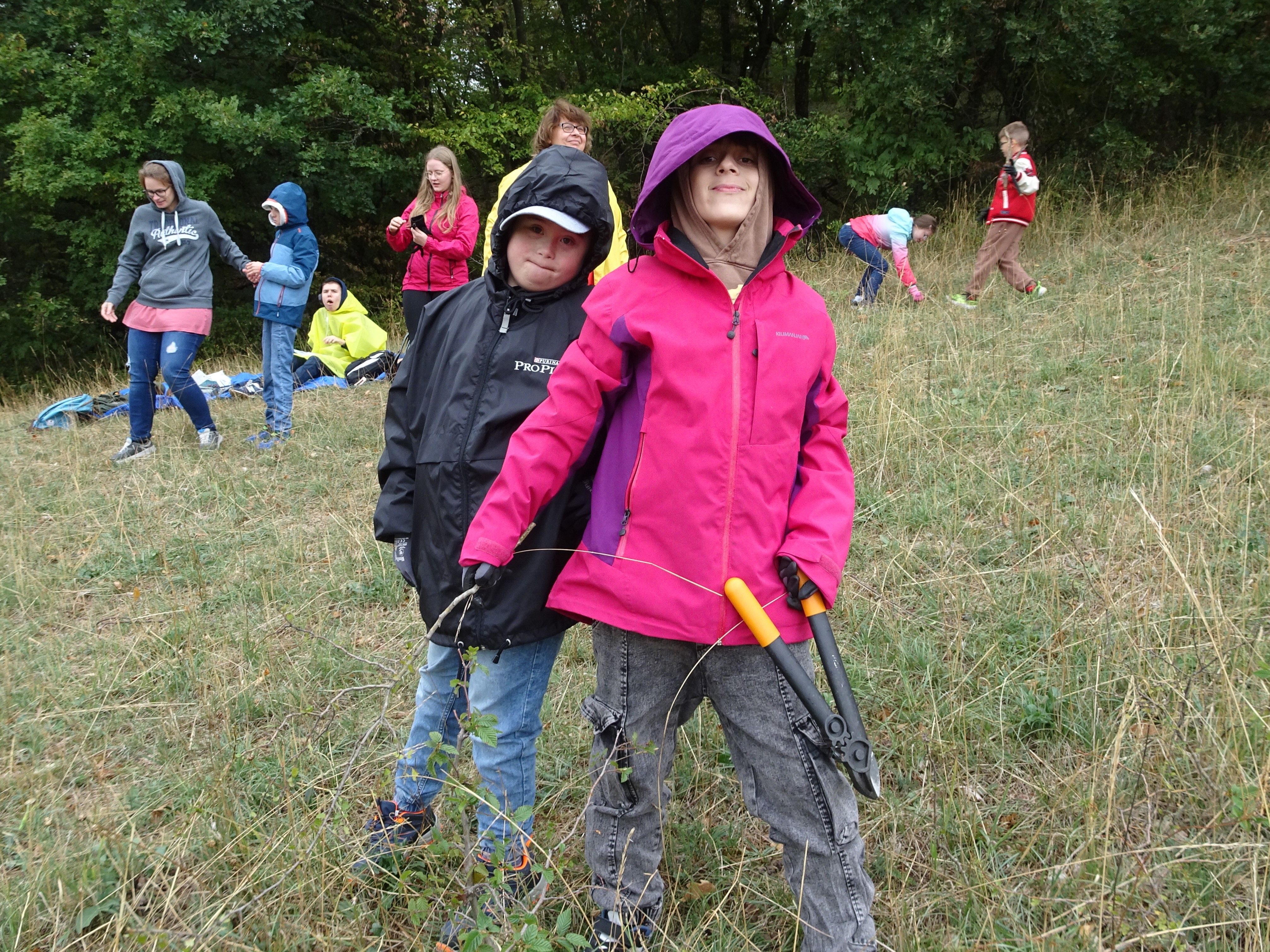 Kinder posieren mit Astschere