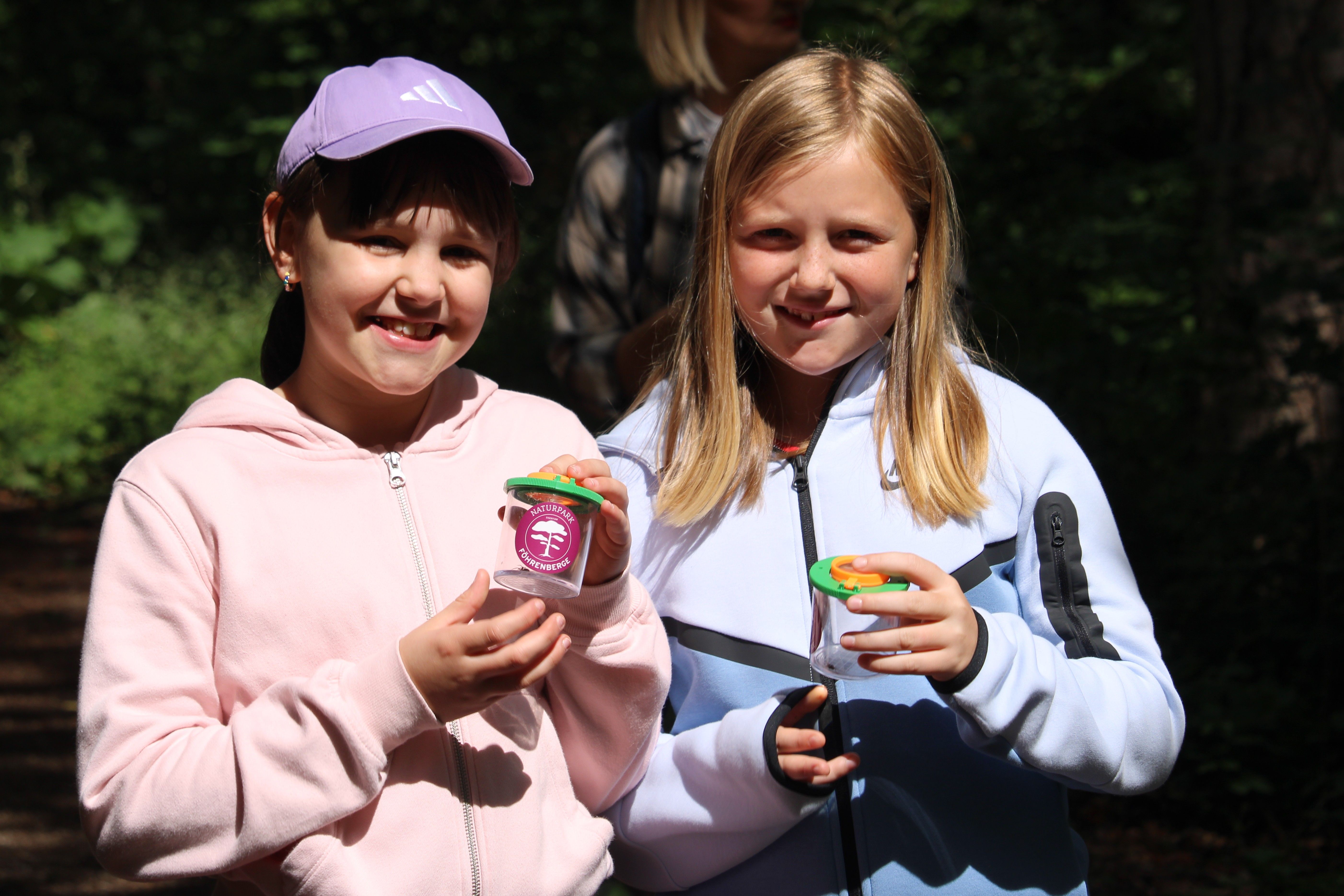 Kinder präsentieren Becherlupe