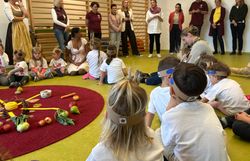 Kindergartenkinder sitzen im Kreis und hören der Rede von Frau Landesrat Rosenkranz zu.