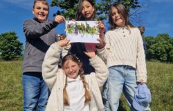 Kinder präsentieren ihr Wiesenklebebild