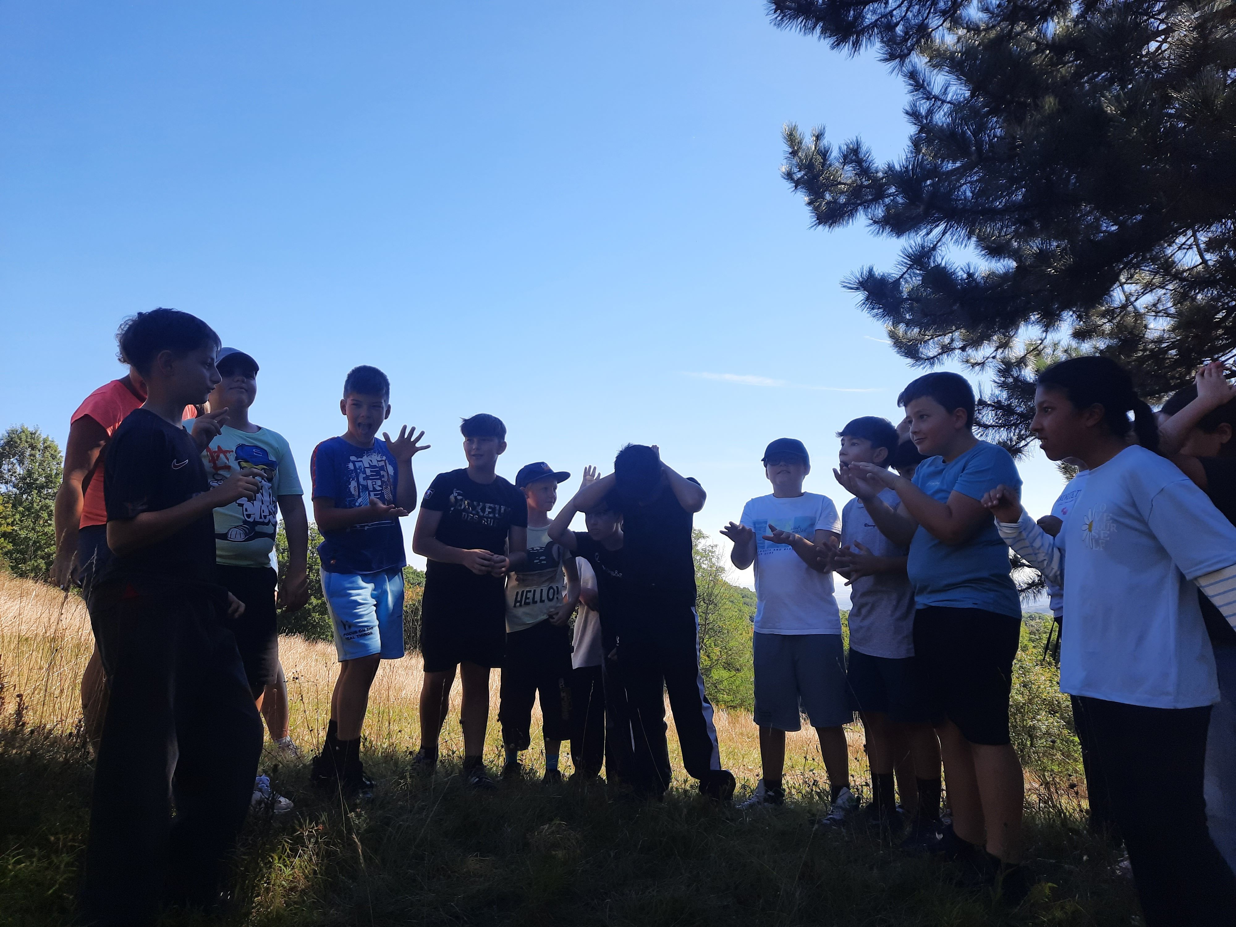 Kinder zeigen sich Begriffe, die im Zusammenhang mir dem Trockenrasen auf der Perchtoldsdorfer Heide stehen pantomimisch vor.
