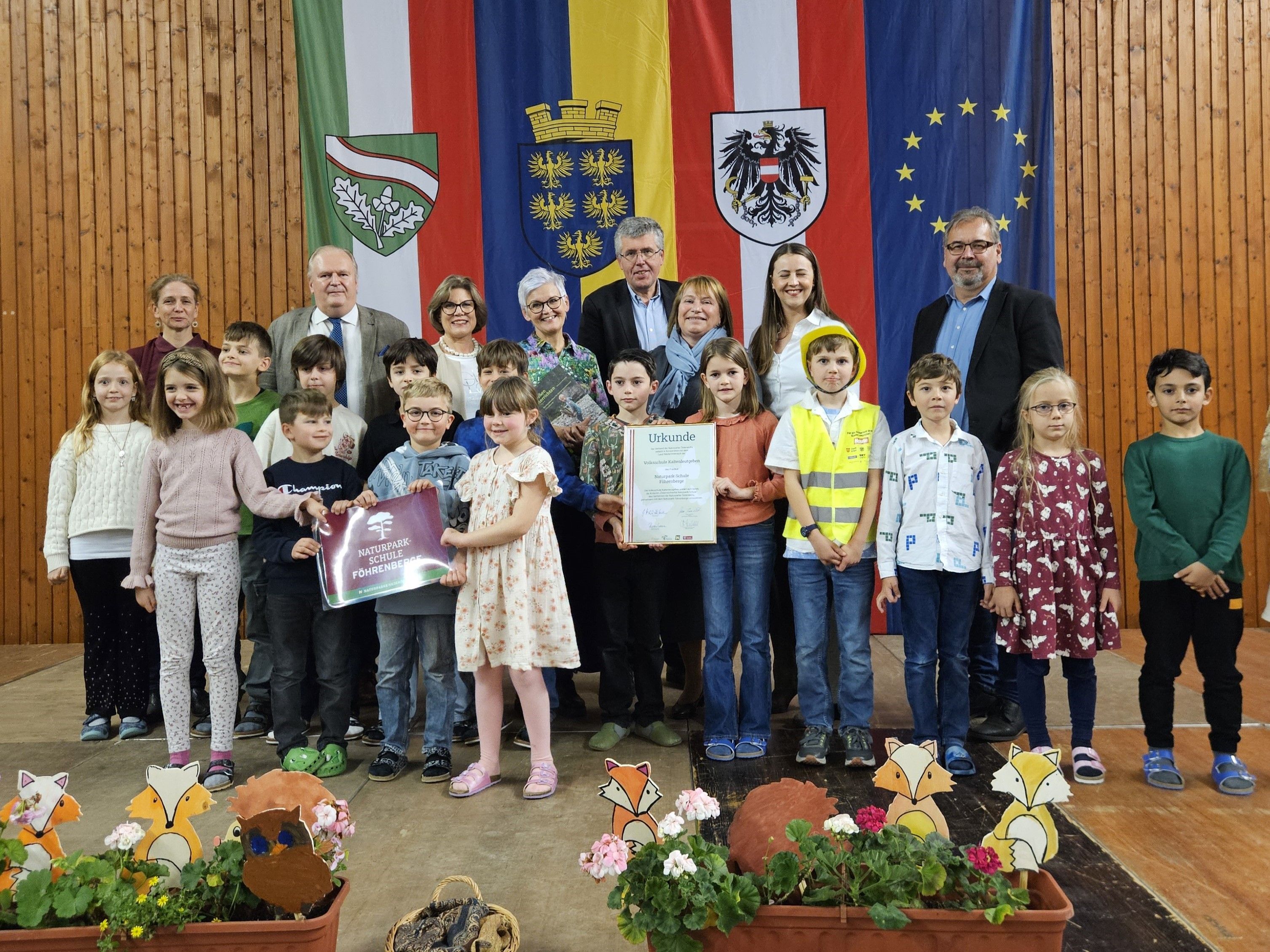 Gruppenfoto der Vertreter:innen von Naturpark Ö/NÖ/Föhrenberge, Gemeinde Kaltenleutgeben und Volksschule Kaltenleutgeben bei der Prädikatisierung zur Naturpark-Schule.
