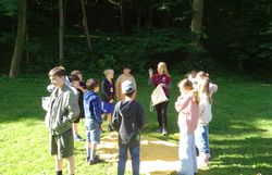 Naturvermittlerin zeigt den Kindern einen Gegenstand 