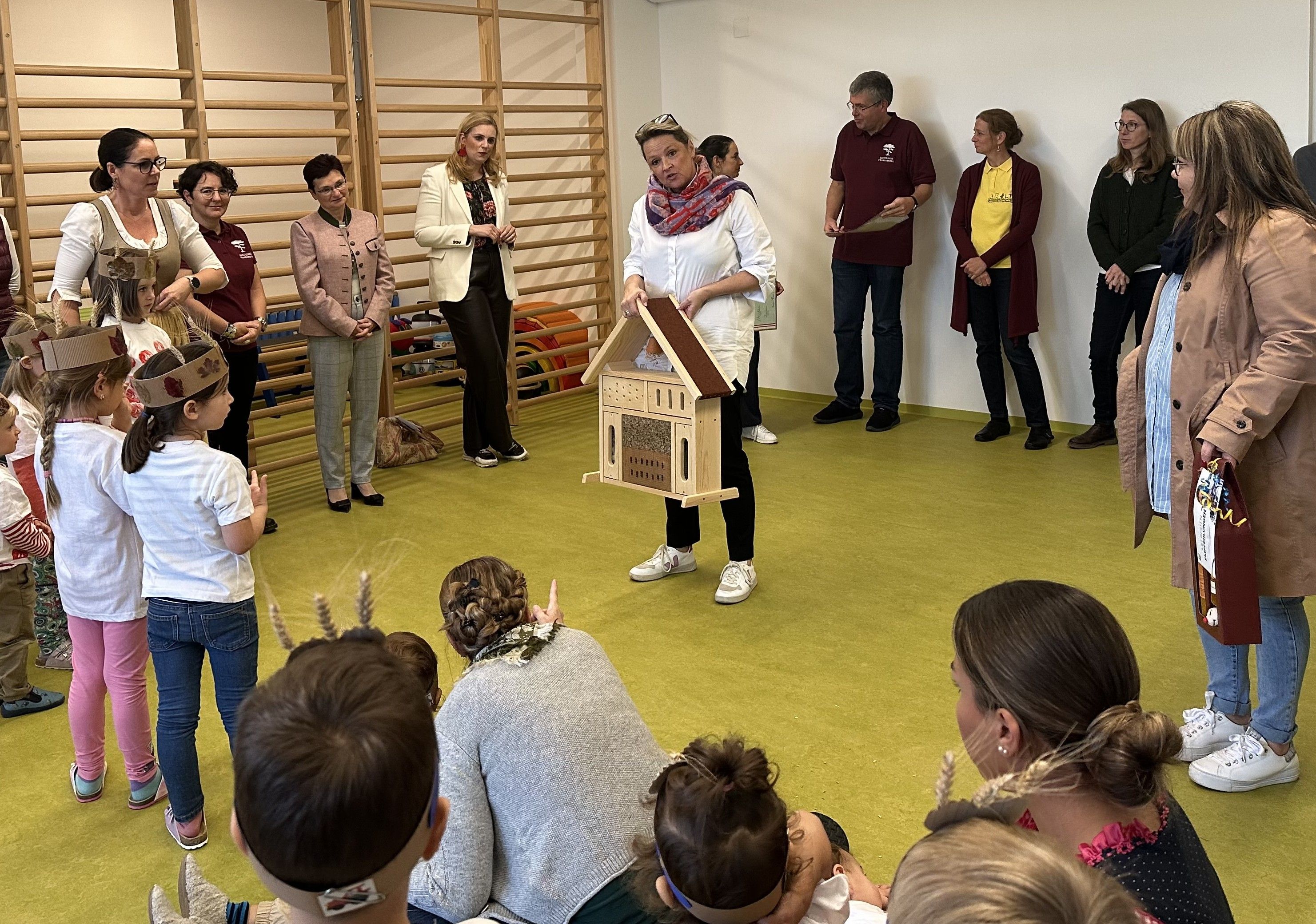 Landesrat Susanne Rosenkranz präsentiert den Kindergartenkindern ihre mitgebrachte Insektenhilfe.  