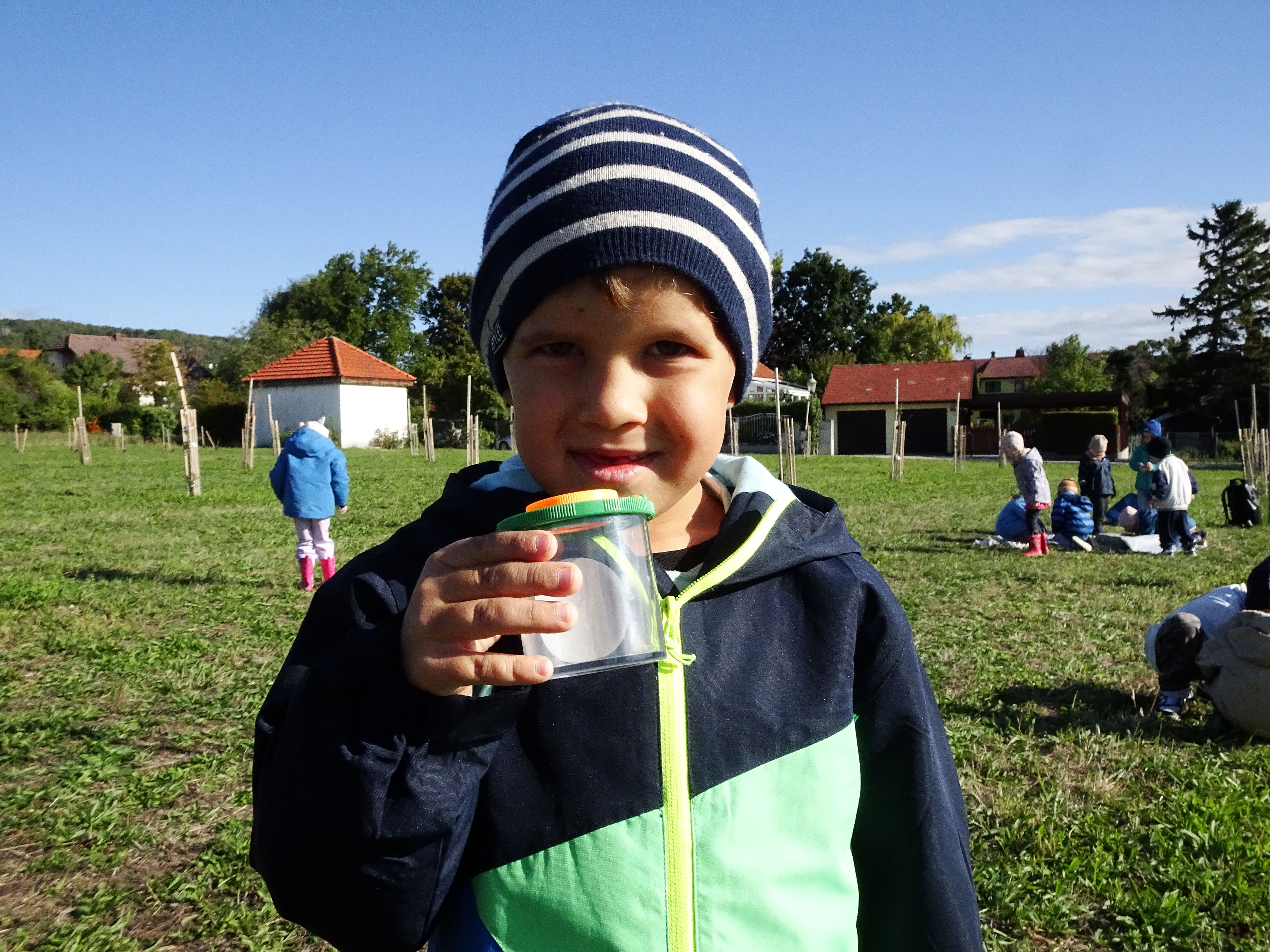 Kind mit Becherlupe