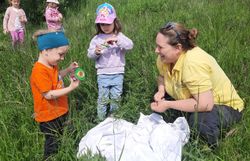 Kinder betrachten gemeinsam mit Biologin Linda die eingefangenen Insekten. 