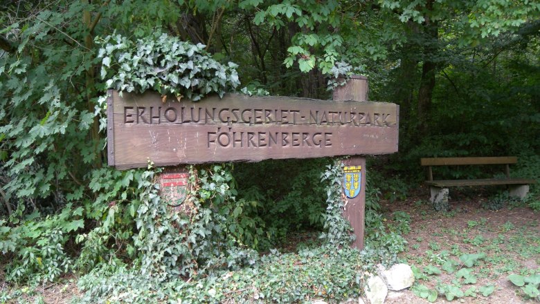 Holztafel mit eingeschnitzter Inschrift Erholungsgebiet Naturpark Föhrenberge