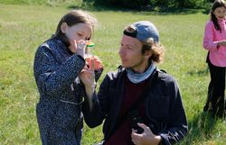 Naturvermittler betrachtet mit einem Kind ein Insekt