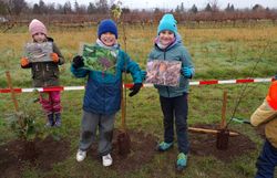 Kinder zeigen Bildfolien zu den eingesetzten Gehölzen.