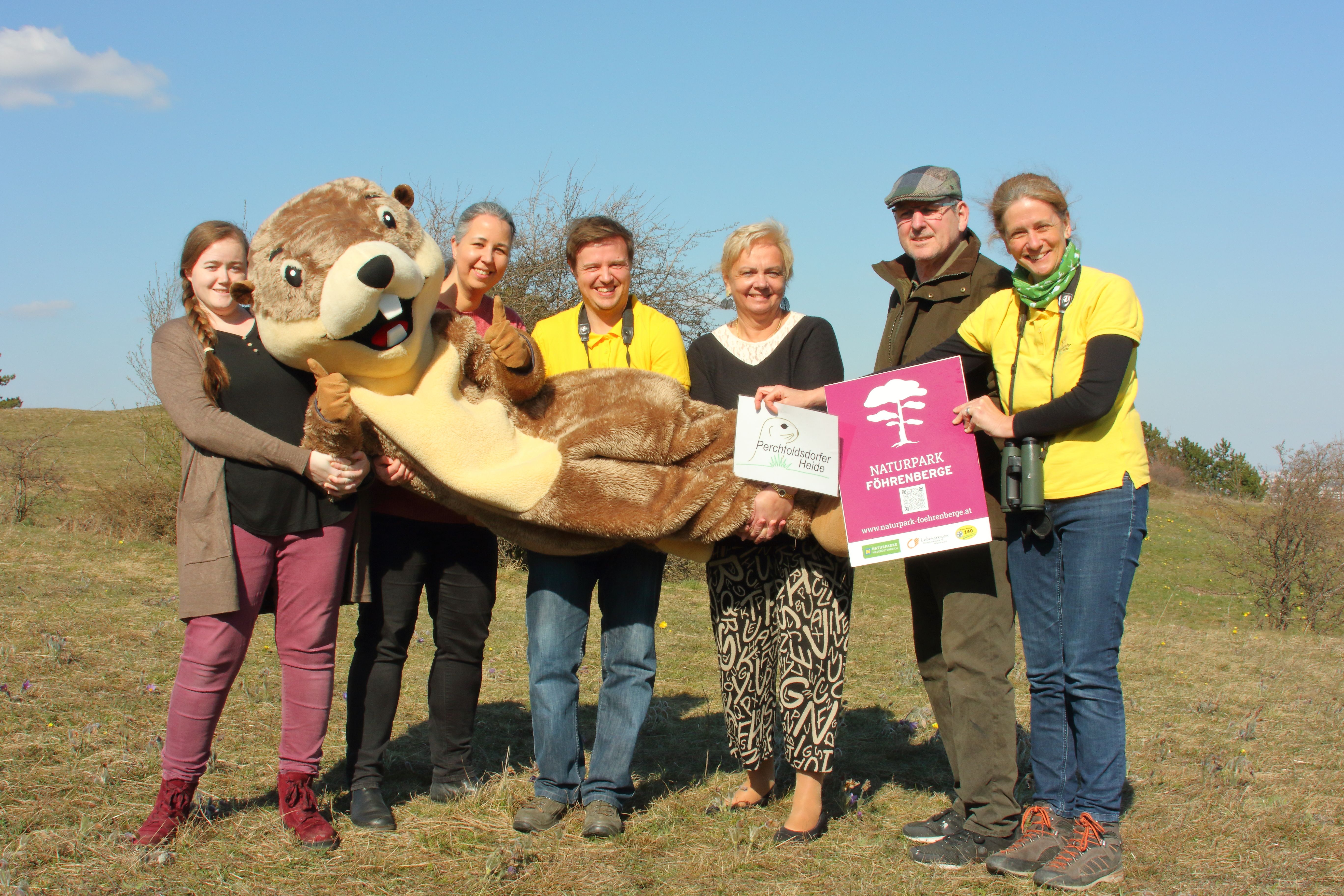 Menschen in einer Gruppe mit Ziesel-Maskottchen PERZI