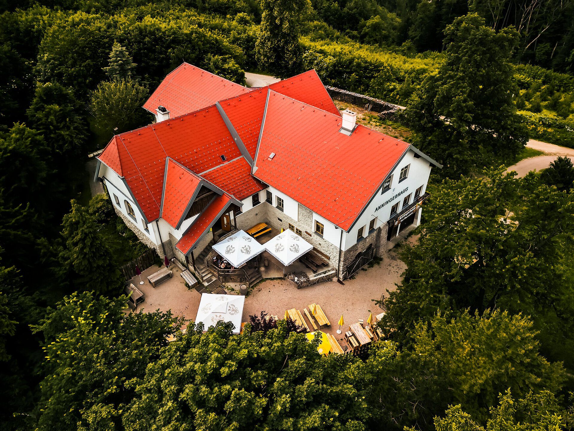 Umgeben von üppigem Grün und majestätischen Bäumen, lädt das Anningerhaus zu einer wohlverdienten Pause ein. Hier genießen Besucher die frische Bergluft und den Blick auf die sanften Hügel des Wienerwaldes, während sie sich mit regionalen Köstlichkeiten stärken.