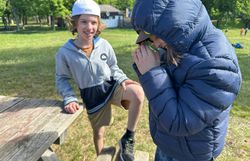 Kinder betrachten ihre Insektenfunde durch die Becherlupe