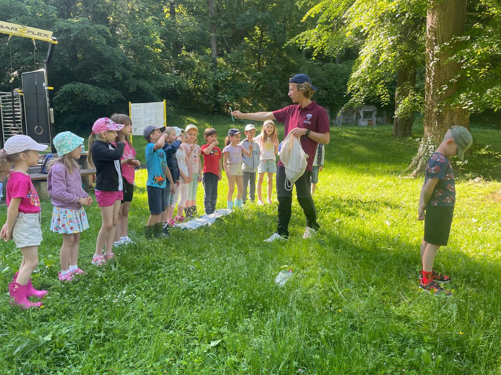 Naturvermittler zeigt den Kindern einen Gegenstand