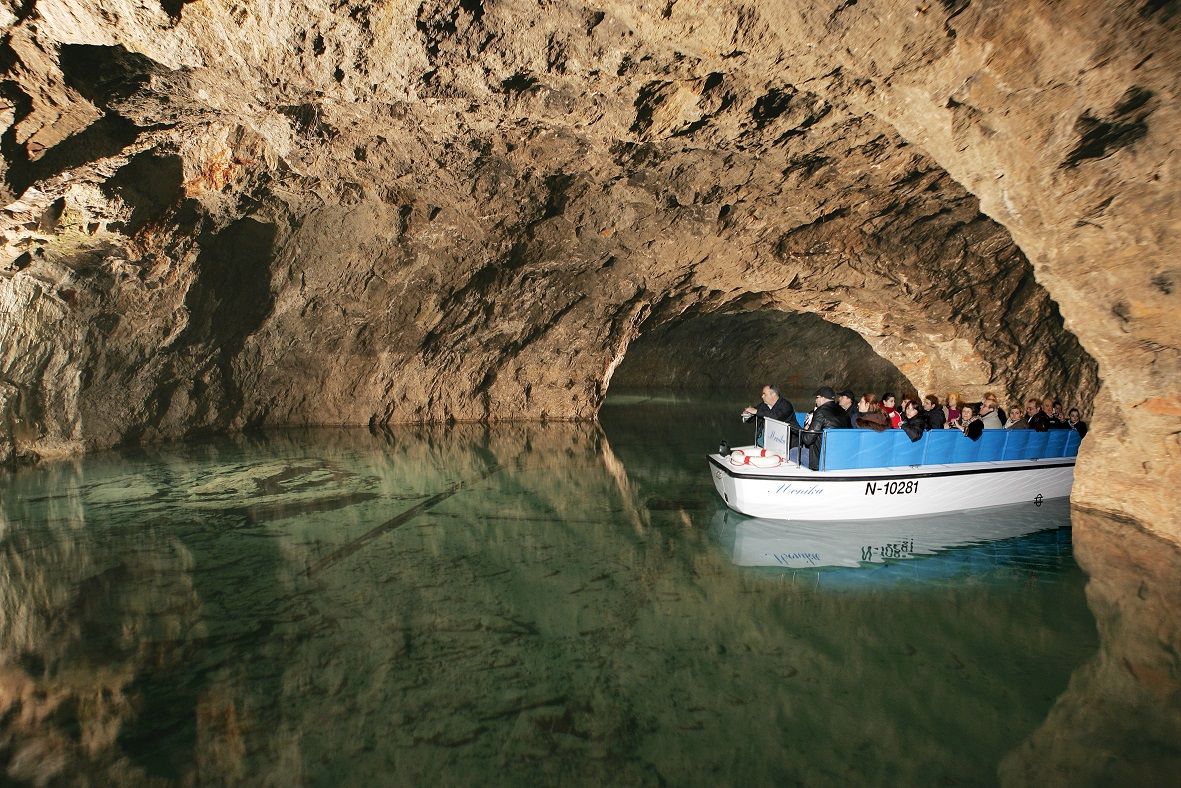 Bootstour in einer unterirdischen Höhle mit Touristen auf einem kleinen Boot.